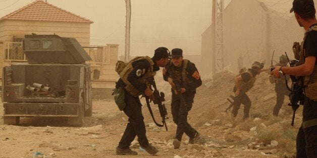 Security forces defend their headquarters against attacks by Islamic State extremists during sand storm in the eastern part of Ramadi, the capital of Anbar province, 115 kilometers (70 miles) west of Baghdad, Iraq, Thursday, May 14, 2015. Islamic State extremists tend to take advantage of bad weather when they attack Iraqi security forces positions, an Iraqi officer said. (AP Photo)