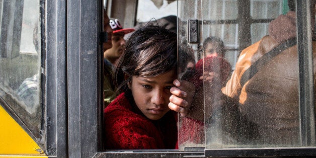 KATHMANDU, NEPAL - APRIL 29: A young girl waits on board a bus to be evacuated from the city center on April 29, 2015 in Kathmandu, Nepal. A major 7.8 earthquake hit Kathmandu mid-day on Saturday, and was followed by multiple aftershocks that triggered avalanches on Mt. Everest that buried mountain climbers in their base camps. Many houses, buildings and temples in the capital were destroyed during the earthquake, leaving over 4600 dead and many more trapped under the debris as emergency rescue workers attempt to clear debris and find survivors. Regular aftershocks have hampered recovery missions as locals, officials and aid workers attempt to recover bodies from the rubble. (Photo by Chris McGrath/Getty Images)