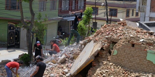 Nepalese residents clear rubble of a collapsed house after an earthquake in Ramkot on the outskirts of Kathmandu on May 17, 2015. Nearly 8,500 people have now been confirmed dead in the disaster, which destroyed more than half a million homes and left huge numbers of people without shelter with just weeks to go until the monsoon rains. AFP PHOTO / PRAKASH MATHEMA (Photo credit should read PRAKASH MATHEMA/AFP/Getty Images)