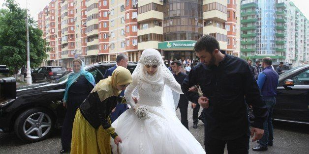 A bride, Chechen Kheda Goilabiyeva, is taken by head of the Chechen leader's administration Magomed Daudov to a wedding registry office for her wedding with Chechen police officer Nazhud Guchigov, in Chechnya's provincial capital Grozny, Russia, Saturday, May 16, 2015. A 46-year-old Chechen police officer taking a 17-year-old as his second wife in flagrant violation of Russian laws has caused a storm in the Russian media and put the regionâs ruler on the defensive. (AP Photo)
