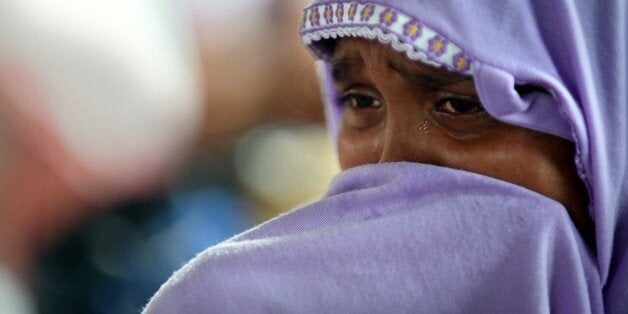 Hasina Begam, a rescued migrant Rohingya woman, cries as she grieves for her brother from the new confinement area in the fishing town of Kuala Langsa in Aceh province on May 16, 2015 where hundreds of migrants from Myanmar and Bangladesh, mostly Rohingyas, are taking shelter after they were rescued by Indonesian fishermen. Hasina's brother Abdullah was thrown in the sea after he was killed by Bangladeshi migrants during a bloody struggle for survival between Bangladeshis and Rohingya in their two months on the boat. Washington raised the pressure on Southeast Asia to open its ports to boatpeople May 16 after migrants described a terrifying battle for survival between Rohingya and Bangladeshi passengers as their shunned vessel sank off Indonesia. AFP PHOTO / ROMEO GACAD (Photo credit should read ROMEO GACAD/AFP/Getty Images)