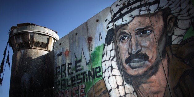 RAMALLAH, WEST BANK - AUGUST 24: A mural of the late Palestinian leader Yasser Arafat adorns the wall of the Israeli seperat