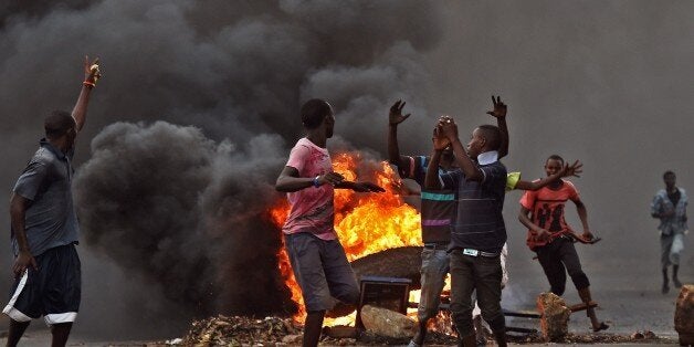 Protestors opposed to the Burundian president Pierre Nkurunziza's third term in office gather by a burning barricade during