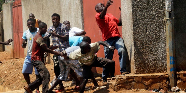 Protester throw stones at police during clashes in the Nyakabyga neighborhood of Bujumbura, Burundi, Thursday May 21, 2015. Protests continue against the President's decision to seek a third term. ( AP Photo/Jerome Delay)