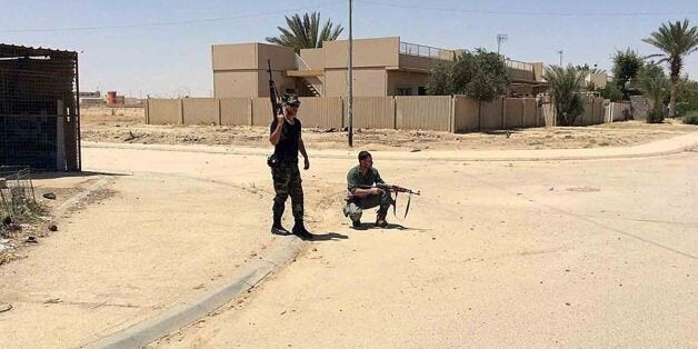 Sunni tribal fighters stand guard on patrol to protect their neighborhoods against Islamic State extremists in al-Baghdadi to