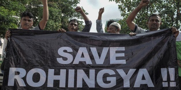 Ethnic Rohingya refugees from Myanmar residing in Malaysia hold a banner during a protest outside the Myanmar embassy in Kuala Lumpur on May 21, 2015, demanding Yangon to end the persecution and ill-treatment of the Rohingya community which the government does not recognise officially. Myanmar was braced on May 21 for its first talks with US and Southeast Asian envoys on the migrant exodus from its shores, as Malaysia ordered search and rescue missions for thousands of boatpeople stranded at sea. AFP PHOTO / MOHD RASFAN (Photo credit should read MOHD RASFAN/AFP/Getty Images)