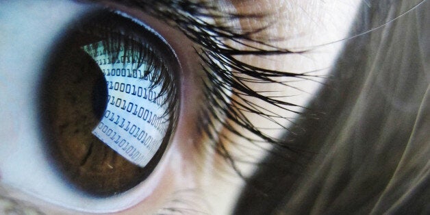 A pictures shows binary code reflected from a computer screen in a woman's eye on October 22, 2012. AFP PHOTO / LEON NEAL