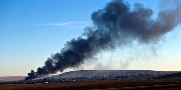 Smoke rises from an Islamic State position in eastern Kobani, after an airstrike by the US led coalition, seen from a hilltop outside Suruc, on the Turkey-Syria border Saturday, Nov. 8, 2014. Kobani, also known as Ayn Arab, and its surrounding areas, has been under assault by extremists of the Islamic State group since mid-September and is being defended by Kurdish fighters. (AP Photo/Vadim Ghirda)