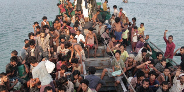 FILE - In this Wednesday, May 20, 2015 file photo, migrants wait to be be rescued by Acehnese fishermen on their boat on the