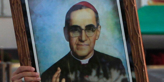 A pilgrim carries a portrait of Roman Catholic Archbishop Oscar Romero to Romero's beatification ceremony in San Salvador, El Salvador, Saturday, May 23, 2015. Huge crowds are expected at the ceremony to beatify Romero, who was cut down by an assassin's bullet 35 years ago and declared a martyr for his faith this year by Pope Francis. (AP Photo/Moises Castillo)