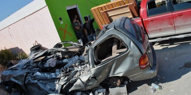 A car lies destroyed in front of a house after a tornado struck May 25, 2015 in Ciudad Acuna, northern Mexico, leaving at least 13 dead people and flattening hundreds of homes in a deadly six-second blast of carnage. AFP PHOTO/RAUL LLAMAS (Photo credit should read RAUL LLAMAS/AFP/Getty Images)