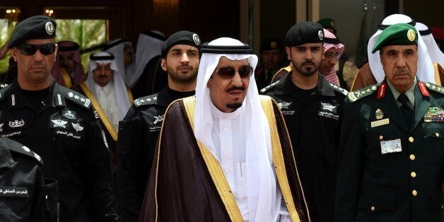 Saudi King Salman bin Abdulaziz (C) walks surrounded by security officers to receive Bahraini King Hamad bin Isa al-Khalifa (