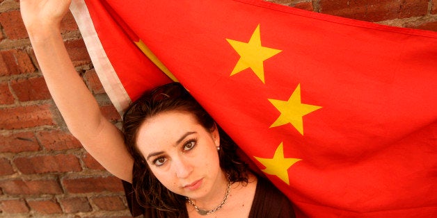 Melissa Sconyers, who studied abroad in China, is photographed with a Chinese flag in San Francisco, Monday, Aug. 11, 2008. China is hoping that American college students watching the Summer Olympics will want to travel there, providing a bump similar to what Australia and Greece enjoyed in 2000 and 2004. China is the seventh most popular destination for U.S. students, according to the Institute of International Education. But it's growing so quickly that, if trends continue, it will soon pass countries like Britain, Spain and Italy and become the most popular. (AP Photo/Jeff Chiu)