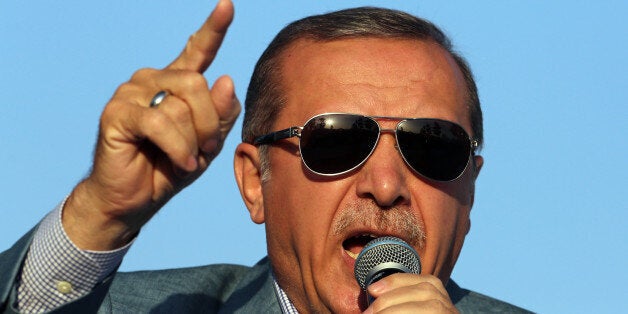 Turkey's President Recep Tayyip Erdogan addresses a rally in the courtyard of historical Haci Bayram Mosque in Ankara, Turkey, Tuesday, May 26, 2015. Earlier in the day, Erdogan showed a copy of Islam's holy book, Quran, in Kurdish language during a ceremony in Hakkari at the border with Iraq. Turkish opposition parties accuse Erdogan of exploiting religious values and symbols to favor the ruling Justice and Development Party ahead of the June 7 general elections. Erdogan has held Kurdish-language copies of the Quran during several rallies in the countryâs mainly Kurdish, eastern and southeastern provinces. Opposition parties say his move is in breach of Turkish laws banning the use of religion in politics.(AP Photo/Burhan Ozbilici)