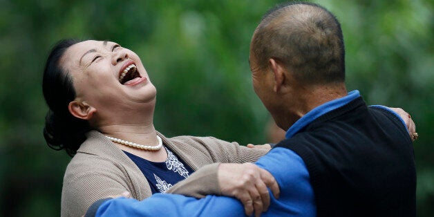 A Chinese woman laughs during a social dance with a man at Ritan Park in Beijing, China Thursday, Oct. 30, 2014. Levels of se