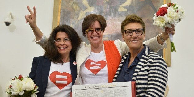 Same-sex couple Daniela Bellisario and Barbara Vecchieti pose with gay rights activist Imma Battaglia (R) after they registered their civil union at Rome's city hall on May 21, 2015 in Rome. The city of Rome organized today a 'Celebration Day' to registrate civil unions including same-sex ones. Italy's Justice Minister Andrea Orlando said yesterday the country needs a civil unions law and a draft bill by ruling Democratic Party (PD) should be presented in parliament by the end of July. AFP PHOTO / TIZIANA FABI (Photo credit should read TIZIANA FABI/AFP/Getty Images)