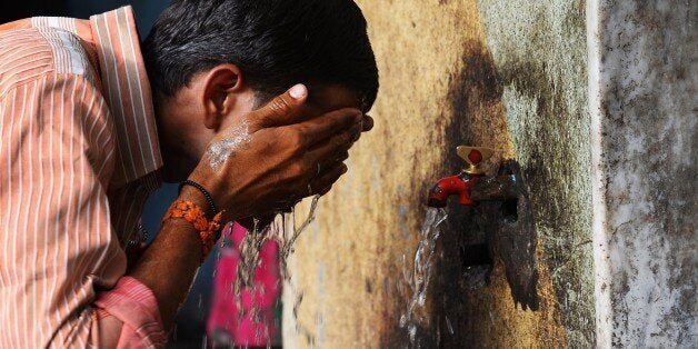 An Indian man washes his face at a roadside tap during rising temperatures in New Delhi on May 28, 2015. Hospitals in India battled May 28, 2015 to treat victims of a blistering heatwave that has claimed nearly 1,500 lives in just over a week -- the highest number recorded in two decades. AFP PHOTO / SAJJAD HUSSAIN (Photo credit should read SAJJAD HUSSAIN/AFP/Getty Images)