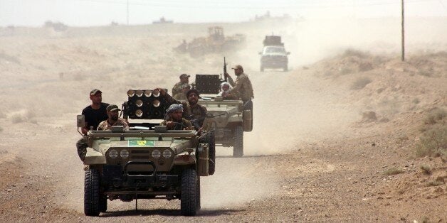 Iraqi security forces and paramilitaries deploy, on May 26, 2015, in al-Nibaie area, north-west of Baghdad, during an operation aimed at cutting off Islamic State (IS) jihadists in Anbar province before a major offensive to retake the city of Ramadi. Iraqi forces closed in on Ramadi and launched the operation dubbed Labaik ya Hussein', which roughly translates as 'We are at your service, Hussein' and refers to one of the most revered imams in Shiite Islam. It will see a mix of security forces and paramilitaries move south towards the city from Salaheddin province, said Hashed al-Shaabi ('popular mobilisation' in Arabic) spokesman Ahmed al-Assadi. AFP PHOTO/AHMAD AL-RUBAYE (Photo credit should read AHMAD AL-RUBAYE/AFP/Getty Images)