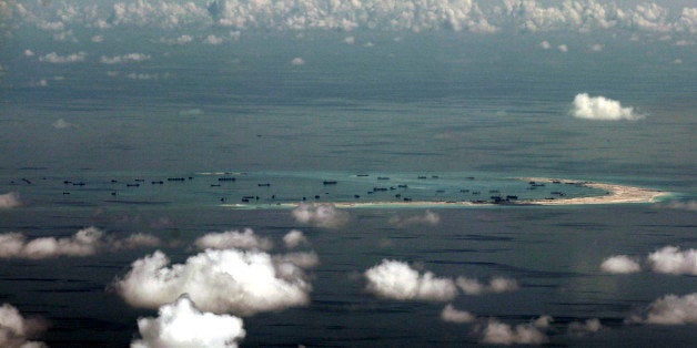 This areal photo taken through a glass window of a military plane shows China's alleged on-going reclamation of Mischief Reef