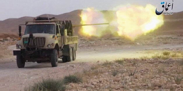 This image made from a militant video posted on YouTube on Tuesday, May 26, 2015, which has been verified and is consistent with other AP reporting, purports to show an armored vehicle of the Islamic State group firing ammunition in Jezel oil fields near Palmyra, Syria. The militant video purportedly showed Islamic State group fighters battling Syrian government forces around the Jezel oil field near Palymra. (Militant video via AP)