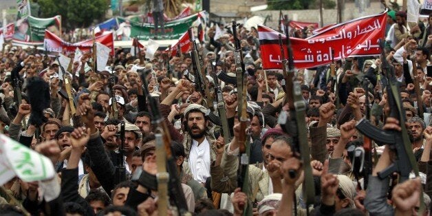 Supporters of the Shiite Huthi movement brandish their weapons during a demonstration against the Saudi-led air strikes, in t