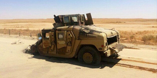 A destroyed Iraqi army humvee is left behind outside of the northern city of Mosul, Iraq, Wednesday, June 25, 2014, more than two weeks after the al-Qaida-inspired Islamic Sate of Iraq and the Levant (ISIL) took over the country's second largest city. U.S. Secretary of State John Kerry warned Mideast nations on Wednesday against taking new military action in Iraq that might heighten already-tense sectarian divisions, as reports surfaced that Syria launched airstrikes across the border and Iran has been flying surveillance drones over the neighboring country. (AP Photo)