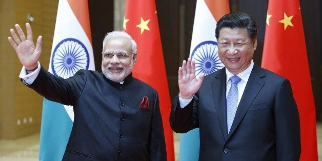 India's Prime Minister Narendra Modi (L) and China's President Xi Jinping wave to journalists before they hold a meeting in Xian, in China's Shaanxi province, on May 14, 2015. Modi began a three-day trip to China on May 14 by inspecting the Terracotta Warriors as a festering border dispute colours relations between the Asian giants. AFP PHOTO / POOL / Kim Kyung-Hoon (Photo credit should read KIM KYUNG-HOON/AFP/Getty Images)