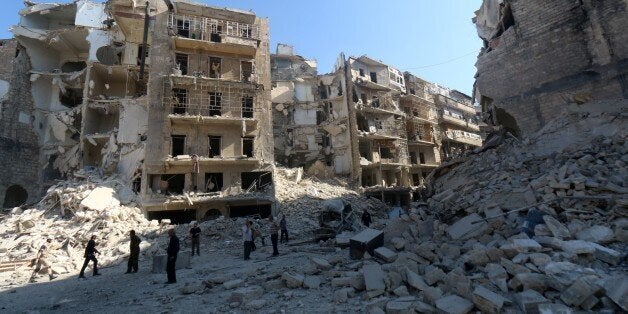Syrians stand amidst the destruction in the eastern Shaar neighbourhood of the northern Syrian city of Aleppo on May 30, 2015