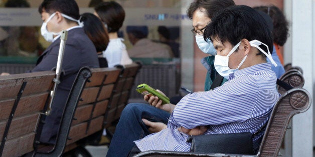 South Koreans wearing masks as a precaution against the Middle East Respiratory Syndrome virus sit at an emergency room at Se
