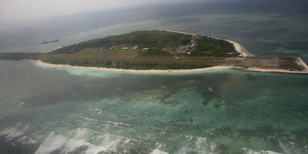 Photographed through the window of a closed aircraft, an aerial view shows Pagasa Island, part of the disputed Spratly group of islands, in the South China Sea located off the coast of western Philippines Wednesday July 20, 2011. China protested a trip made by Filipino lawmakers to disputed areas in the South China Sea to assert the claim of the Philippines. Ethan Sun, spokesman for the Chinese embassy in Manila, said the trip scheduled was 'against the spirit' of a code of conduct signed by claimants to the areas in 2002. The Spratlys, believed to be rich in oil, mineral and marine resources, are also claimed in whole or partly by Brunei, Malaysia, Vietnam and Taiwan. (AP Photo/Roley Dela Pena, Pool)
