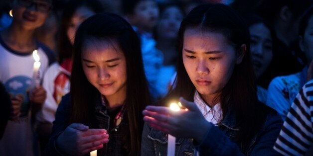 Local residents take part in a candlelight vigil to pay their respect to victims of the sunken ship in Jianli, in China's Hubei province on June 4, 2015. Distraught and angry relatives rushed to the site of a capsized cruise ship in China seeking news of their loved ones, as rescue workers recovered dozens of dead bodies. AFP PHOTO / JOHANNES EISELE (Photo credit should read JOHANNES EISELE/AFP/Getty Images)