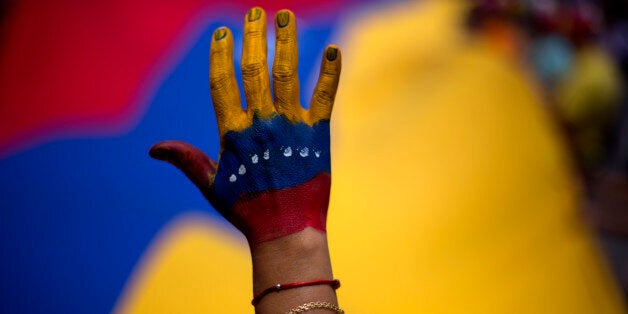 A woman with her hand painted with the colors of the Venezuelan flag attends a rally in support of opposition leader Leopoldo