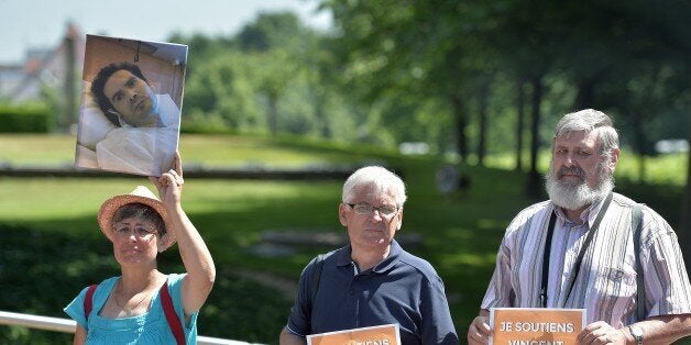 People hold placards reading 'I show support to Vincent' and a picture of Vincent Lambert, a quadriplegic man who is currently on artificial life support in a hospital in Reims, during a hearing regarding Lambert's case at the European Court of Human Rights in the eastern French city of the Strasbourg on June 5, 2015. Europe's rights court upheld the decision of a French court to allow a man in a vegetative state to be taken off life support, in a ruling that could become a benchmark on the continent. For over a year the fate of Vincent Lambert, who was left severely brain damaged and quadriplegic as a result of a 2008 road accident, has torn apart his family in a judicial tug-of-war over his right to die. AFP PHOTO / PATRICK HERTZOG (Photo credit should read PATRICK HERTZOG/AFP/Getty Images)