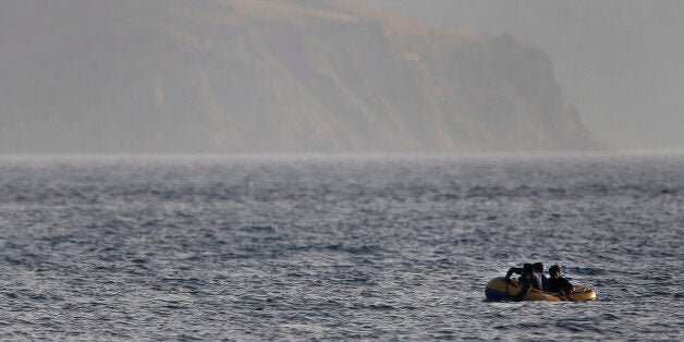Migrants from Pakistan trying to cross from Turkey to Greece, row their dinghy as they approach the island of Kos, Greece, Tu