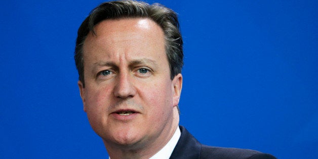 British Prime Minister David Cameron briefs the media during a news conference with German Chancellor Angela Merkel after mee