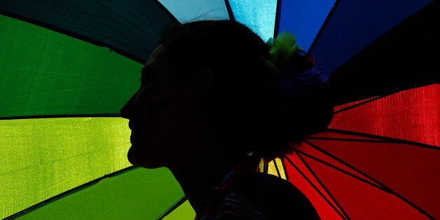 DUBLIN, IRELAND - MAY 23: A supporter in favour of same-sex marriage stands under a rainbow umbrella as thousands gather in Dublin Castle square awaiting the vote outcome on May 23, 2015 in Dublin, Ireland. Voters in the Republic of Ireland are taking part in a referendum on legalising same-sex marriage on Friday. The referendum was held 22 years after Ireland decriminalised homosexuality with more than 3.2m people being asked whether they want to amend the country's constitution to allow gay and lesbian couples to marry. (Photo by Charles McQuillan/Getty Images)