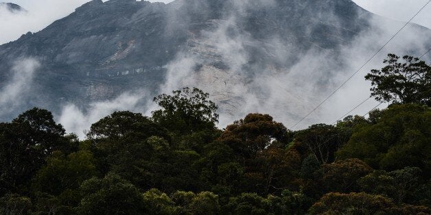 Malaysia's Mount Kinabalu is seen among mists from the Timpohon gate check point a day after the earthquake in Kundasang, a town in the district of Ranau on June 6, 2015. A strong earthquake that jolted Malaysia's Mount Kinabalu killed at least 11 people and left another 8 missing, an official said, as authorities continued to search for survivors on Southeast Asia's highest peak. AFP PHOTO / MOHD RASFAN (Photo credit should read MOHD RASFAN/AFP/Getty Images)