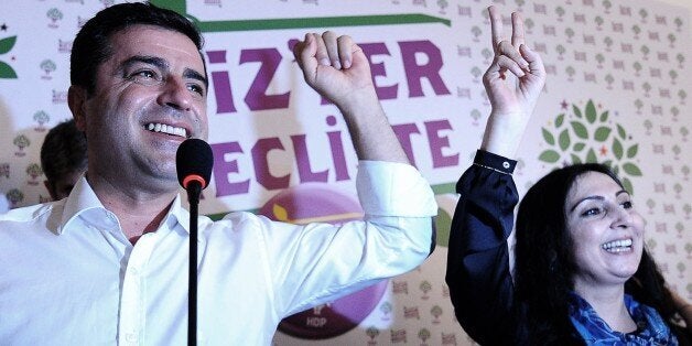 Selahattin Demirtas (L) and Figen Yukseldag (R), co-chairs of the pro-Kurdish Peoples' Democratic Party (HDP), gesture during a press conference in Istanbul on June 7, 2015. Turkey's Islamic-rooted ruling party lost its absolute parliamentary majority in legislative elections, dealing a severe blow to strongman President Recep Tayyip Erdogan's ambition to expand his powers. In a sensational result that shakes-up Turkey's political landscape, the pro-Kurdish People's Democratic Party (HDP) easily surpassed the 10 percent barrier needed to send MPs to parliament. AFP PHOTO / OZAN KOSE (Photo credit should read OZAN KOSE/AFP/Getty Images)