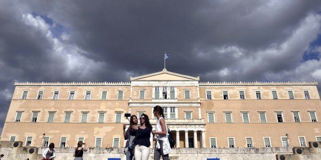 Women take a picture with a selfie stick in front of the Greek parliament in Athens on June 8, 2015. Greece is going to have to make 'tough' choices as it implements reforms to tackle its debt crisis, US President Barack Obama said after a G7 summit. Athens will have to make 'tough decisions' that will be 'good for the long term', stressed Obama following a gathering of world leaders where the tottering Greek economy was high on the agenda. AFP PHOTO / LOUISA GOULIAMAKI (Photo credit should read LOUISA GOULIAMAKI/AFP/Getty Images)
