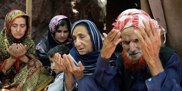 Makhni Begum (2R) and Shah Zula (R) the parents of Pakistani Kashmiri convicted killer Shafqat Hussain, pray as they sit with relatives in Muzaffarabad, the capital of Pakistani-administered Kashmir on June 9, 2015. Relatives of a Pakistani death row prisoner said that they 'felt a wave of life' when his execution was halted to examine claims he was a juvenile when the crime was committed. AFP PHOTO/ Sajjad QAYYUM (Photo credit should read SAJJAD QAYYUM/AFP/Getty Images)