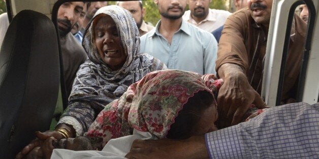 Pakistani Christian relatives of convicted murderer Aftab Bahadur Masih mourn beside his body after his execution in Lahore o