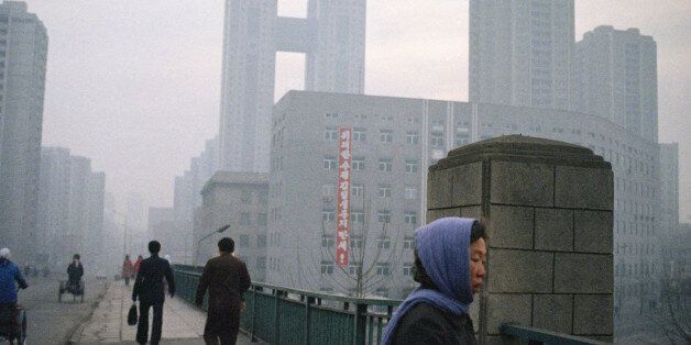 Early commuters in Pyongyang, the capital of North Korea, are greeted by a banner from a building proclaiming "Long Live Great Leader Kim II Sung," March 5, 1989. The twin buildings in background linked by a bridge is the 500-room Hotel Pyongyang Koryo, one of the most modern hotels in North Korean. (AP Photo/Cinty Li)