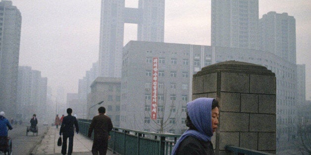 Early commuters in Pyongyang, the capital of North Korea, are greeted by a banner from a building proclaiming "Long Live Grea
