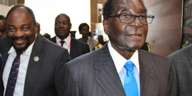 Zimbabwe's President Robert Mugabe, right, arrives for the heads of state meeting of the annual African Union (AU) summit, he