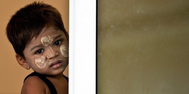 A young Rohingya boy looks on as he waits along with other illegal migrants at a temporary detention center in Langkawi on May 12, 2015. Nearly 2,000 boat people from Myanmar and Bangladesh, many thought to be Rohingya, have been rescued off the coasts of Indonesia and Malaysia. AFP PHOTO / MANAN VATSYAYANA (Photo credit should read MANAN VATSYAYANA/AFP/Getty Images)