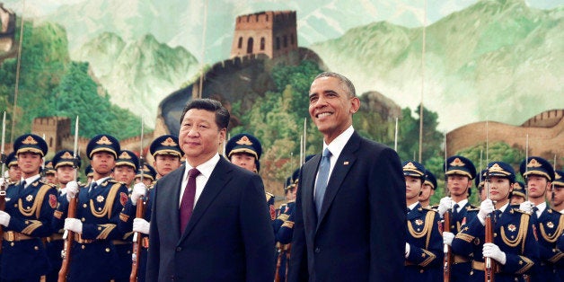 FILE - In this Nov. 12, 2014 file photo, U.S. President Barack Obama, right smiles as a group of children wave flags and flowers during a welcome ceremony held by Chinese President Xi Jinping at the Great Hall of the People in Beijing, China. Xi will make his first state visit as president to the United States in September, Chinese official media reported Wednesday, Feb. 11, 2015, underlining positive momentum in the often-troubled relationship between the worldâs largest economies. (AP Photo/Andy Wong, File)