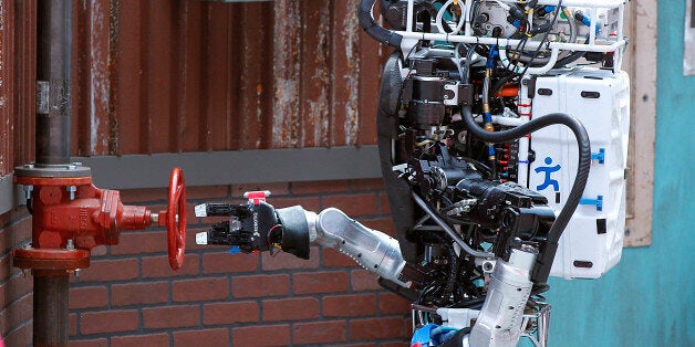 Robot Running Man from the Florida Institute for Human and Machine Cognition proceeds to turn a valve in the next stage of the competition during the U.S. Defense Advanced Research Projects Agency Robotics Challenge in Pomona, Calif., Friday, June 5, 2015. Robots from 24 teams are taking part in a two-day contest hosted by the U.S. Defense Advanced Research Projects Agency, DARPA, to prove their performance in different tasks during a simulated disaster course. (AP Photo/Alex Gallardo)