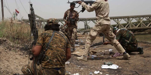 A member of the Popular Mobilisation units opens fire during fightings against Islamic State (IS) militants in the area of Sayed Ghareeb, near Dujail, some 70 kilometres north of Baghdad, on May 28, 2015. AFP PHOTO / MOHAMMED SAWAF (Photo credit should read MOHAMMED SAWAF/AFP/Getty Images)