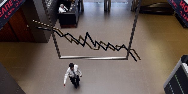 An employee walks through the lobby of the Athens Stock Exchange on June 15, 2015. The Athens stock market plunged more than seven percent after last-ditch debt talks collapsed at the weekend, raising fears of a Greek default and exit from the euro.. AFP PHOTO/ Louisa Gouliamaki (Photo credit should read LOUISA GOULIAMAKI/AFP/Getty Images)