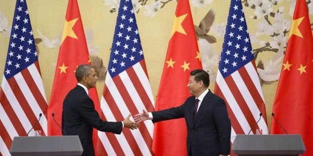 US President Barack Obama (L) and China's President Xi Jinping reach out to shake hands following a bilateral meeting at the Great Hall of the People in Beijing on November 12, 2014. Obama began a one-day state visit after the closing of the Asia-Pacific Economic Cooperation summit. AFP PHOTO / Mandel NGAN (Photo credit should read MANDEL NGAN/AFP/Getty Images)